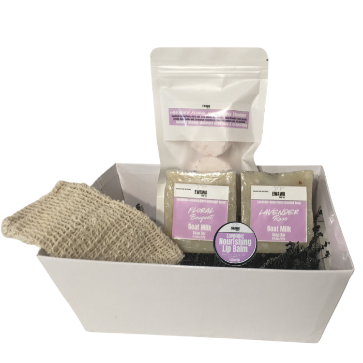 White gift box with skincare products including a scrub, soap, and lip balm on a white background